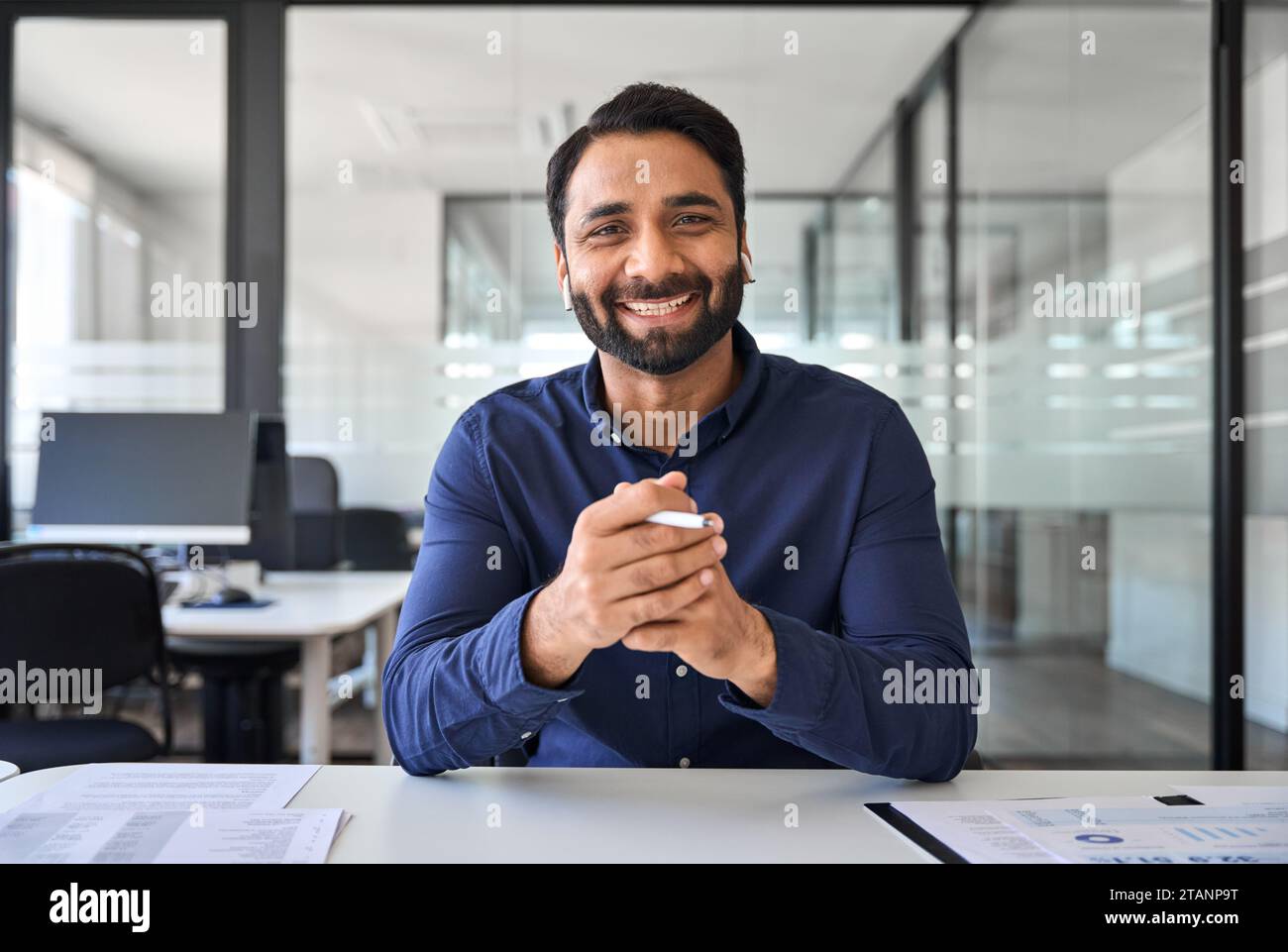 Glücklicher indischer Geschäftsmann, der online ein Hybrid-Meeting im Büro hat. Hochformat. Stockfoto