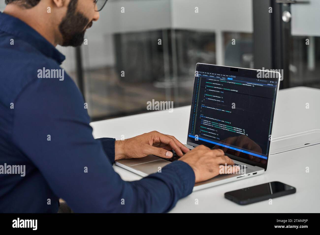 Geschäftiger Softwareentwickler, der im Büro am Computer arbeitet. Über die Schulter Stockfoto