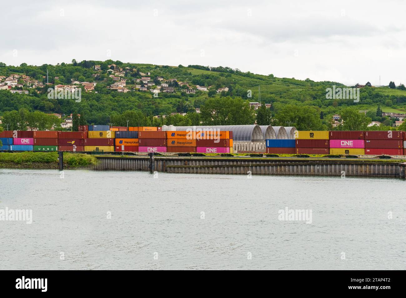 Lyon, Frankreich - 7. Mai 2023: Frachtcontainer am Eisenbahncontainer-Terminal in der Nähe des Flusses. Internationale Frachtlogistik Stockfoto