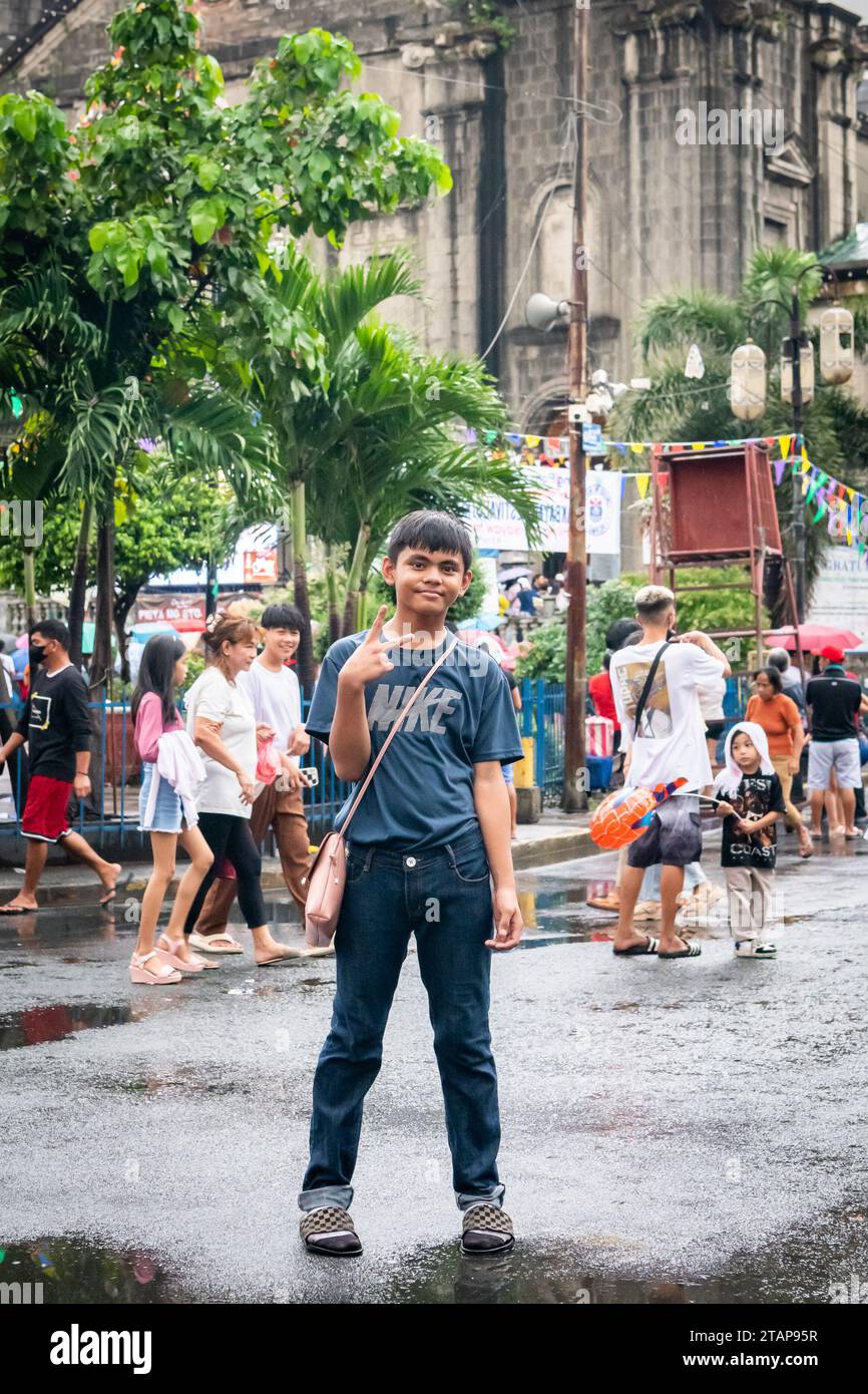 Ein junger philippinischer Junge stellt ein Kind der Kirche Santo Nino de Tondo in Tondo, Manila, auf den Philippinen. Stockfoto