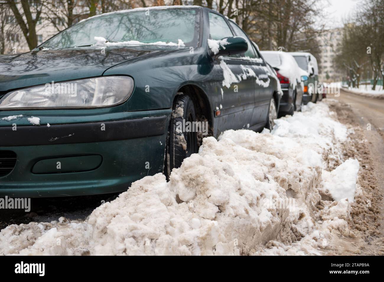 Winter. Die Straße ist mit Schnee bedeckt. Autos, die am Straßenrand geparkt und mit Schnee bedeckt sind Stockfoto