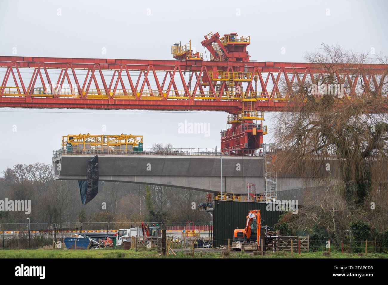 Harefield, Großbritannien. Dezember 2023. Dominique der riesige, orange Trägerkran HS2, der den nächsten Teil des Colne Valley Viaduct in Harefield baut, der neue Hochgeschwindigkeitszüge von London nach Birmingham bringen wird. Das umstrittene Hochgeschwindigkeitsbahnprojekt ist nach wie vor sehr über dem Budget. Die nördliche Phase 2 von HS2 wurde von Rishi Sunak abgesagt, aber es gibt jetzt Bedenken von Bewohnern nördlich von Birmingham, dass, wenn Labour im nächsten Jahr gewählt wird, Keir Starmer von Bürgermeister Andy Burnham angeregt wurde, Phase 2 wiederbeleben könnte. Es wurde berichtet, dass einige Personen auf der unterdrückten HS2-Strecke b Stockfoto