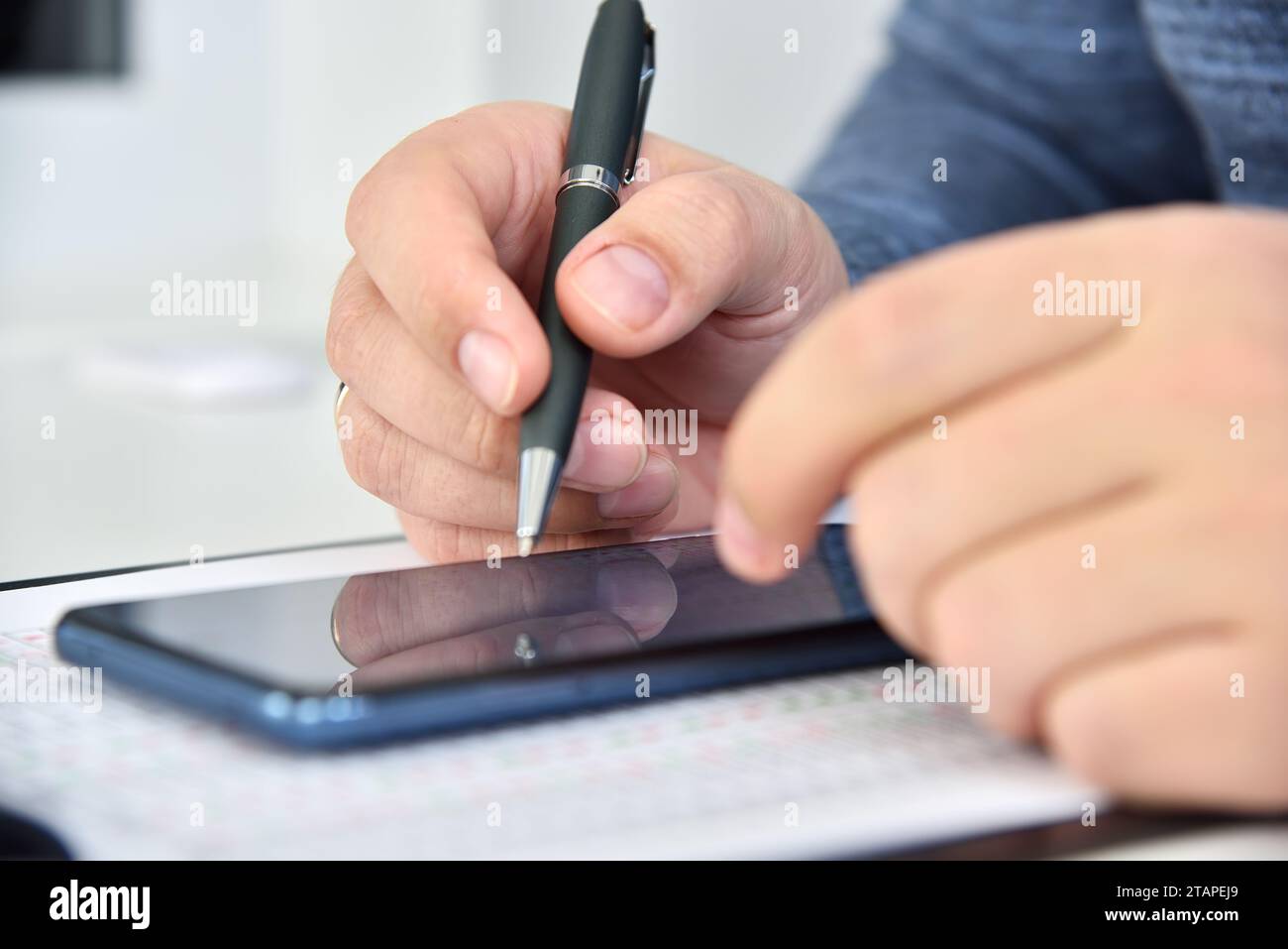 Geschäftsmann mit Smartphone und Geschäftsstatistik auf dem Bildschirm. Internet-Handel und Börsenstatistik. Nahaufnahme Stockfoto