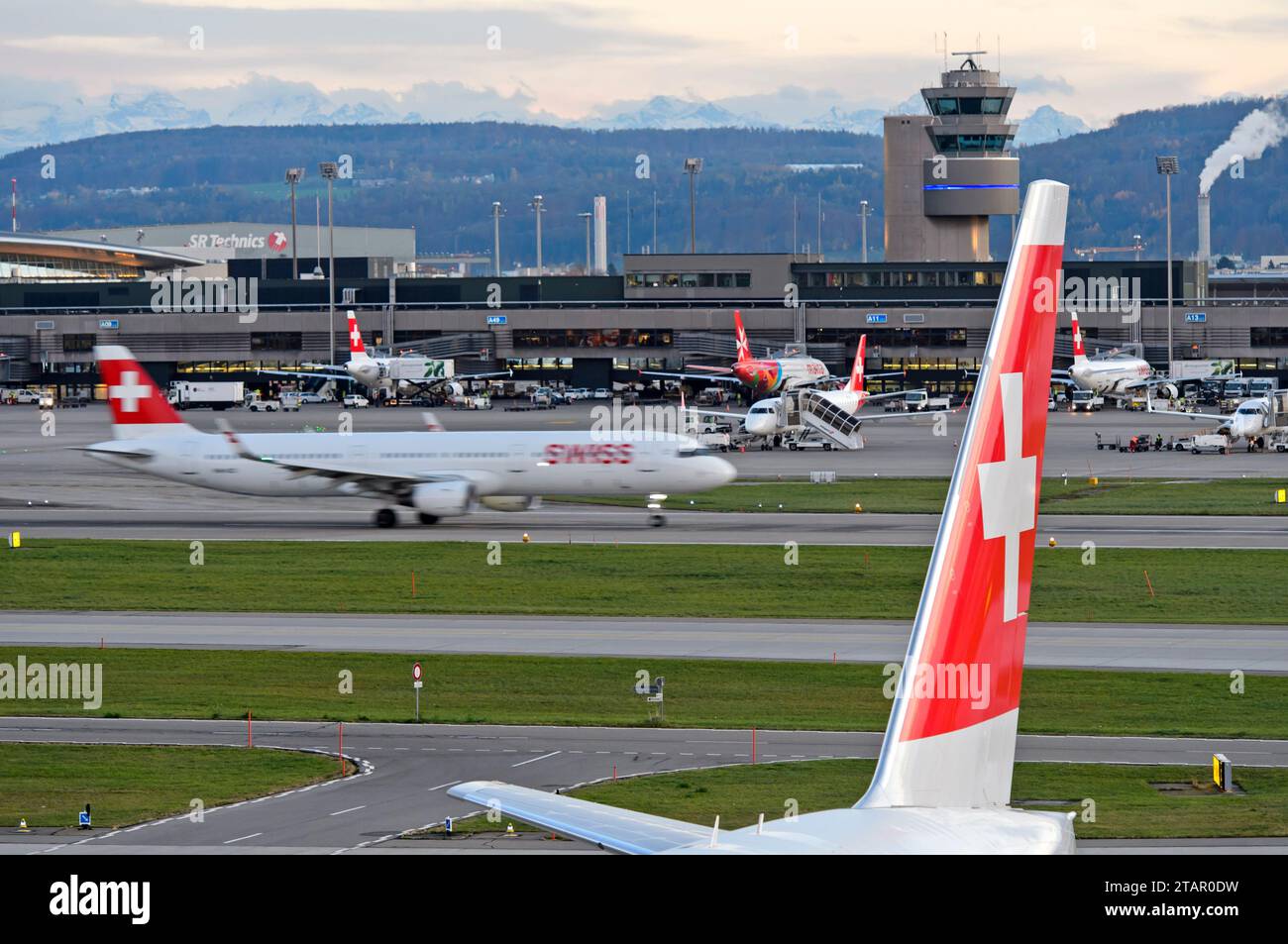 Vertikales Heck eines Airbusses der Swiss International Air Lines mit dem Schweizer Kreuz, hinter einem Flugzeug der Swiss Airlines, das am Flughafen Zürich startet Stockfoto