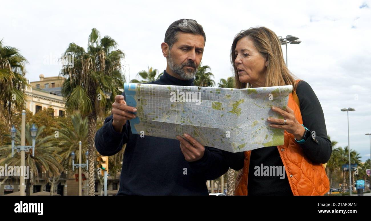 Heterosexuelles Paar in den 40ern Touristen, die sich während des Urlaubs in Barcelona eine Karte in einer Stadt anschauen Stockfoto