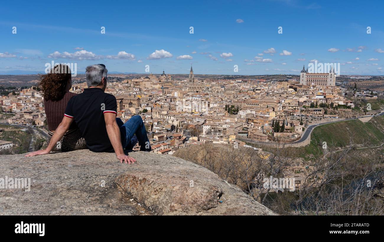 Ein Paar blickt auf die historische Stadt Toledo, die zum UNESCO-Weltkulturerbe gehört. Sie befindet sich auf der Piedra del Rey Moro, einem bekannten Aussichtspunkt über dem Stockfoto