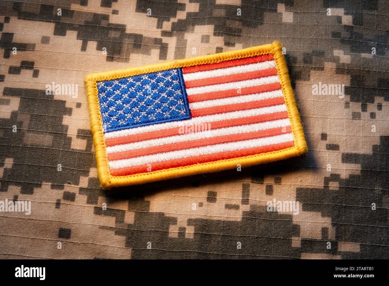 Nahaufnahme eines amerikanischen Flaggenpflasters auf einem Hintergrund militärischer Tarnung, 2023, USA Stockfoto