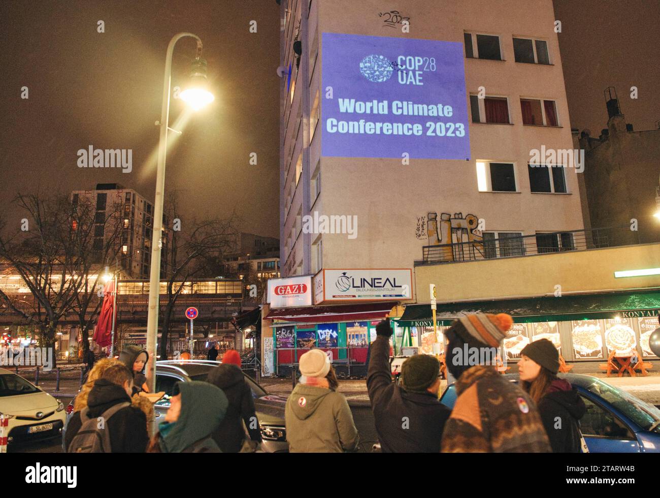 Berlin, Deutschland. Dezember 2023. Aktivisten der Extinction Rebellion protestierten am Abend in Kreuzberg mit einer Lichtprojektion gegen den Einfluss von Fossilien-Lobbygruppen und Unternehmen auf die derzeit stattfindende Klimakonferenz. Quelle: Paul Zinken/dpa/Alamy Live News Stockfoto