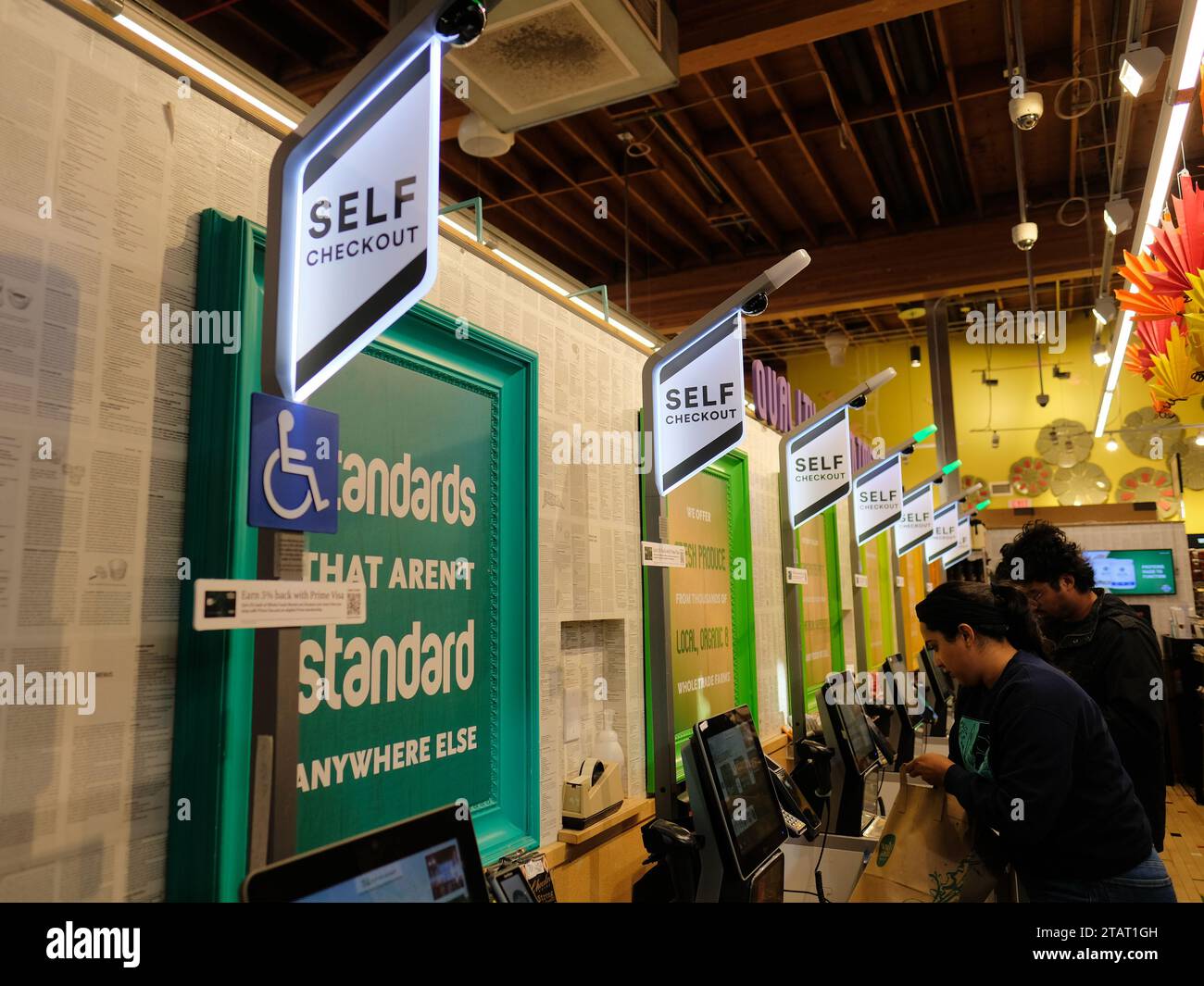 Eine Reihe von automatisierten Selbstkassenbuchten in einem Whole Foods Lebensmittelgeschäft in San Francisco, Kalifornien; Kunden, die sich selbst in einem Supermarkt auschecken. Stockfoto