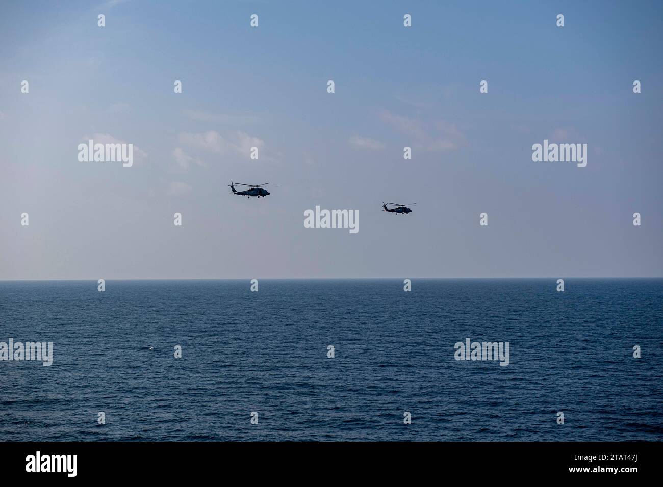 Zwei MH-60R Sea Hawk Helikopter, die an den „Sumpffüchsen“ der Helicopter Maritime Strike Squadron (HSM) 74 befestigt sind, nehmen an einer Zeremonie des Kommandowechsels an Bord des Flugzeugträgers USS Dwight D. Eisenhower (CVN 69) im Golf von Oman am 17. November 2023 Teil. Als Teil der Dwight D. Eisenhower Carrier Strike Group (IKECSG), HSM 74 im US 5th Fleet Area of Operations, um die Sicherheit und Stabilität im Nahen Osten im Seeverkehr zu unterstützen. (Foto der US Navy von Mass Communication Specialist 2nd Class Jorge LeBaron) Stockfoto