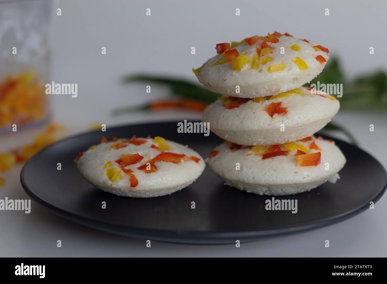 Herzhafte Paprika. Ein farbenfrohes und appetitliches südindisches Frühstück. Gedämpfter herzhafter Reiskuchen mit fermentiertem Teig aus schwarzen Linsen und Ri Stockfoto