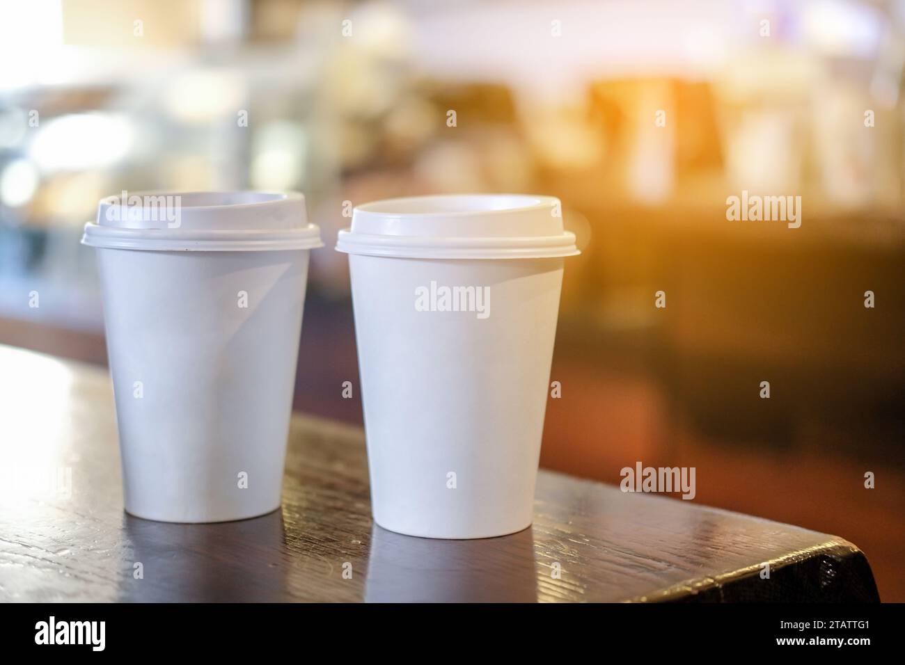 Kaffeetasse zum Mitnehmen mit heißem Getränk auf dem Tisch im Café. Stockfoto