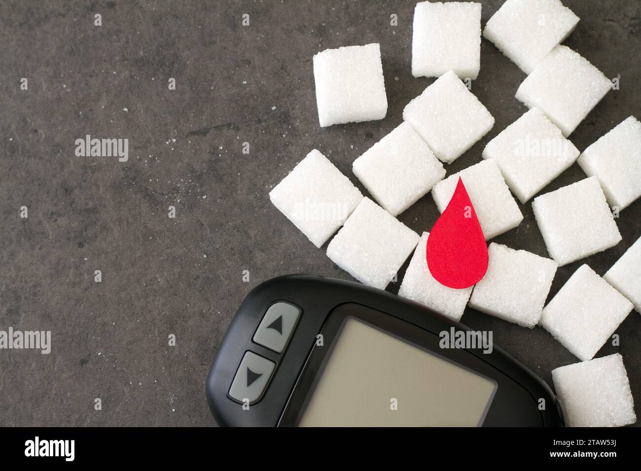Zuckerwürfel mit rotem Bluttropfen und Glucometer, Diabeteskonzept Stockfoto