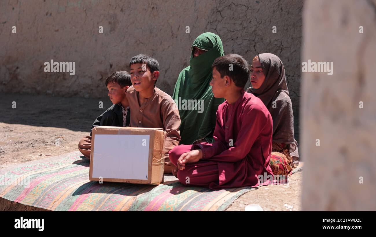 Bedürftige afghanische Familie erhält Spenden | Kinder, die glücklich sind, nachdem sie Nahrungsmittelhilfsmittel erhalten haben. Stockfoto