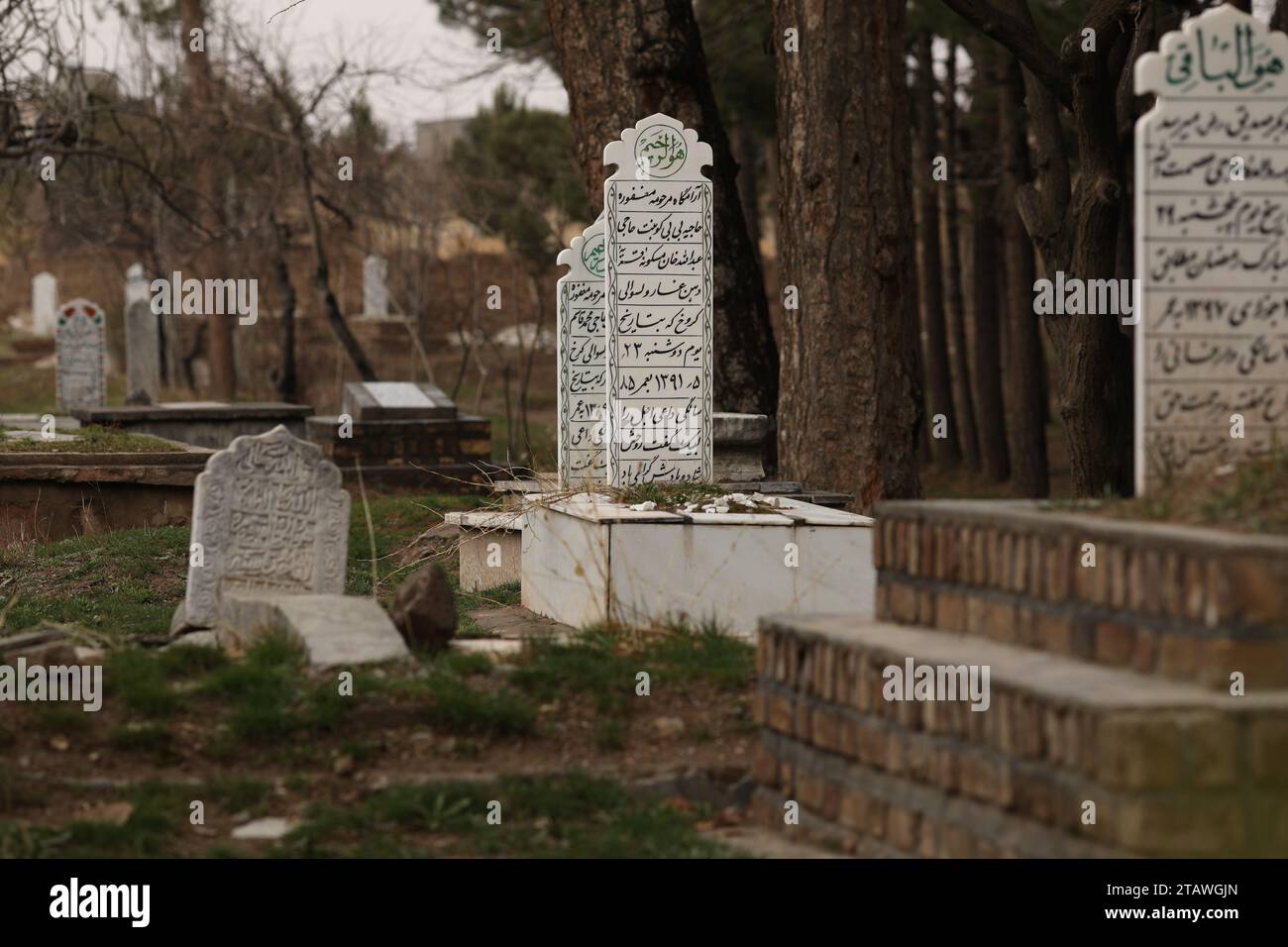 Friedhof in grüner Umgebung, mit einem arabischen Satz auf dem Grab | Foto eines islamischen Grabes. Stockfoto