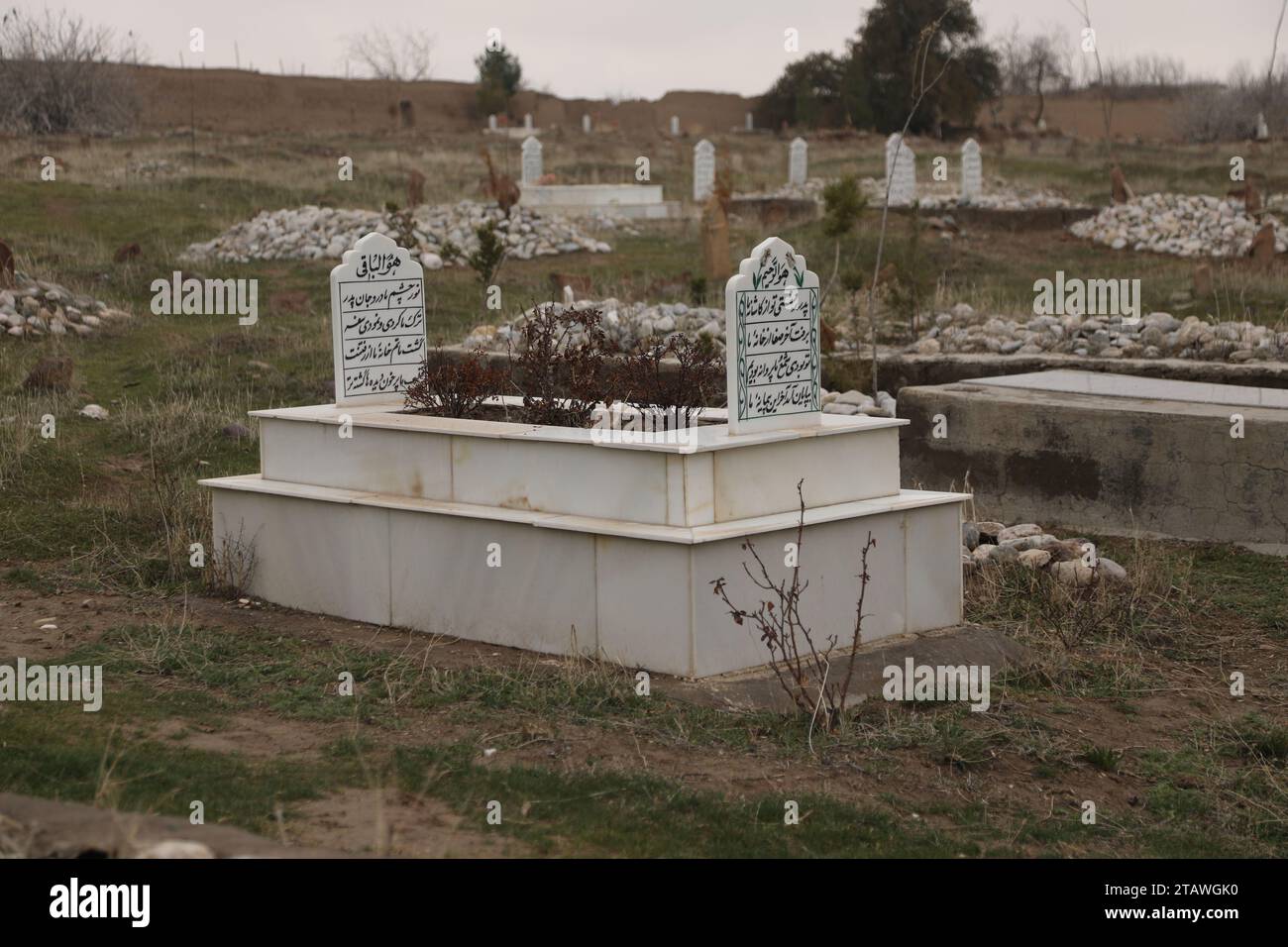 Friedhof in grüner Umgebung, mit einem arabischen Satz auf dem Grab | Foto eines islamischen Grabes. Stockfoto