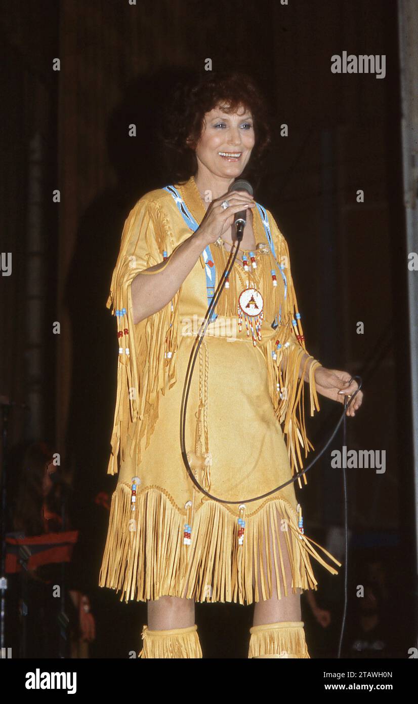 Ein Foto von Country-Superstar LORETTA LYNN aus dem Jahr 1982 auf Stgae in einem braunen Indianerkleid mit Quasten. Stockfoto