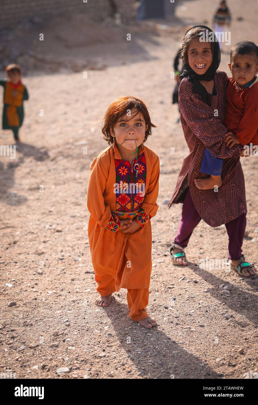 Fröhliches afghanisches Mädchen mit traditionellem Outfit, lächelnd und in die Kamera schauend. Stockfoto