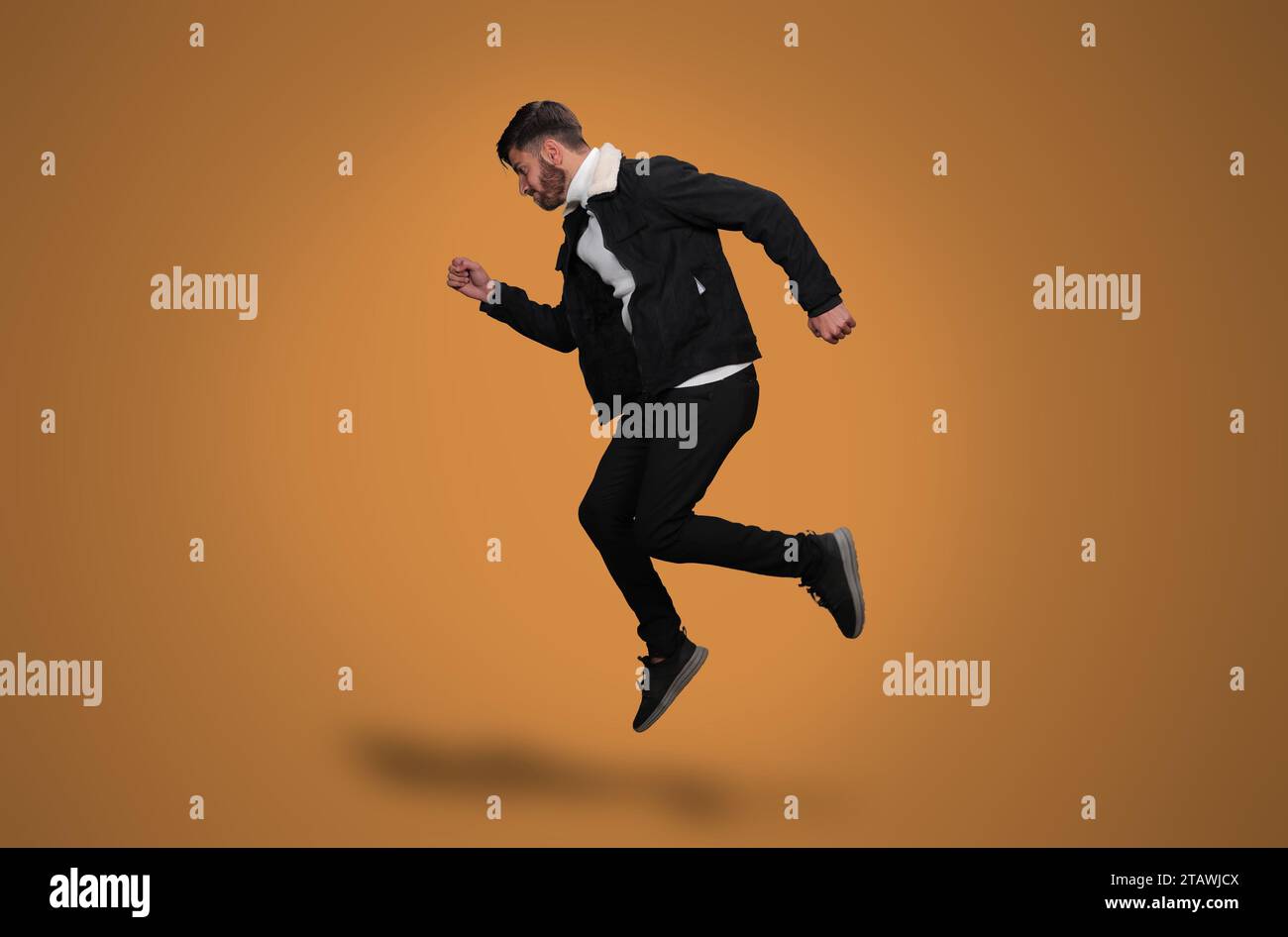 Ein junger Mann springt auf einen gelben Hintergrund | der Mann schwimmt Stockfoto
