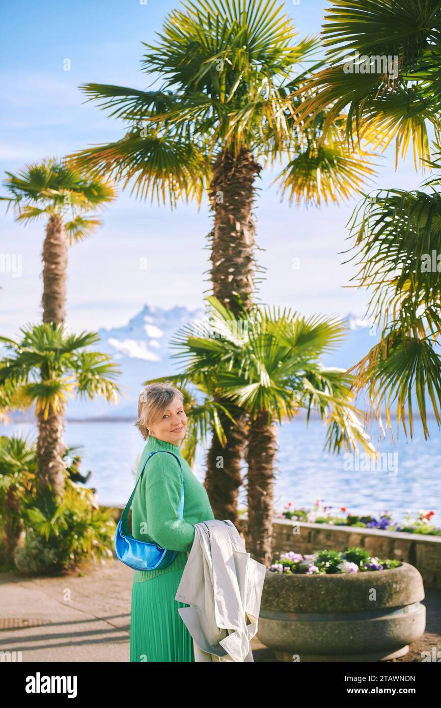 Außenporträt einer glücklichen Reifen 50 - 55-jährigen Frau, die am See vorbeigeht, aufgenommen in Montreux, Waadt, Schweiz Stockfoto