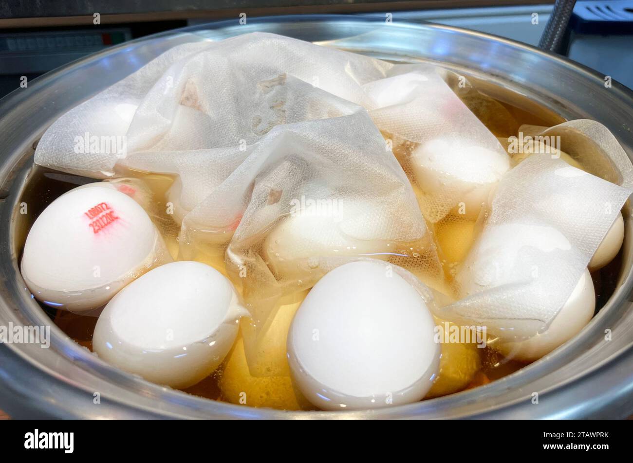 In einem Topf werden frische, ungekochte Eier in geschmackvolle Teeeier verwandelt. Stockfoto