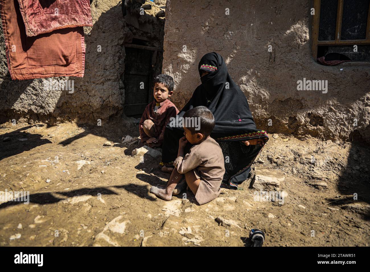 Eine traurige Witwe in Not, begleitet von ihren Kindern, repräsentiert afghanische Familien mit Armut und Not | Flüchtlingsfamilie. Stockfoto