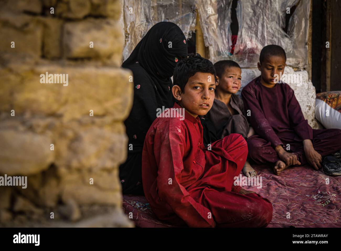 Eine traurige Witwe in Not, begleitet von ihren Kindern, repräsentiert afghanische Familien mit Armut und Not | Flüchtlingsfamilie. Stockfoto