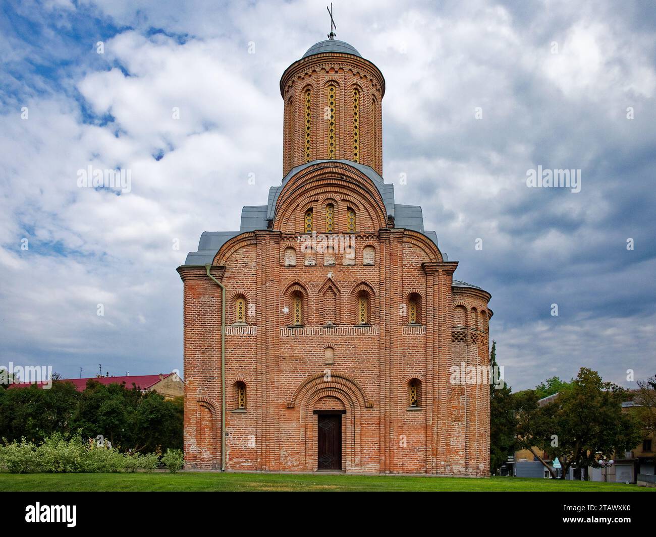 Die Pjatnitskaja-Kirche in Tschernigov, Ukraine, ein rotes Backsteingebäude mit einem hohen Turm, vor einer Kulisse von grünen Bäumen und einem klaren Himmel. Freitag C Stockfoto