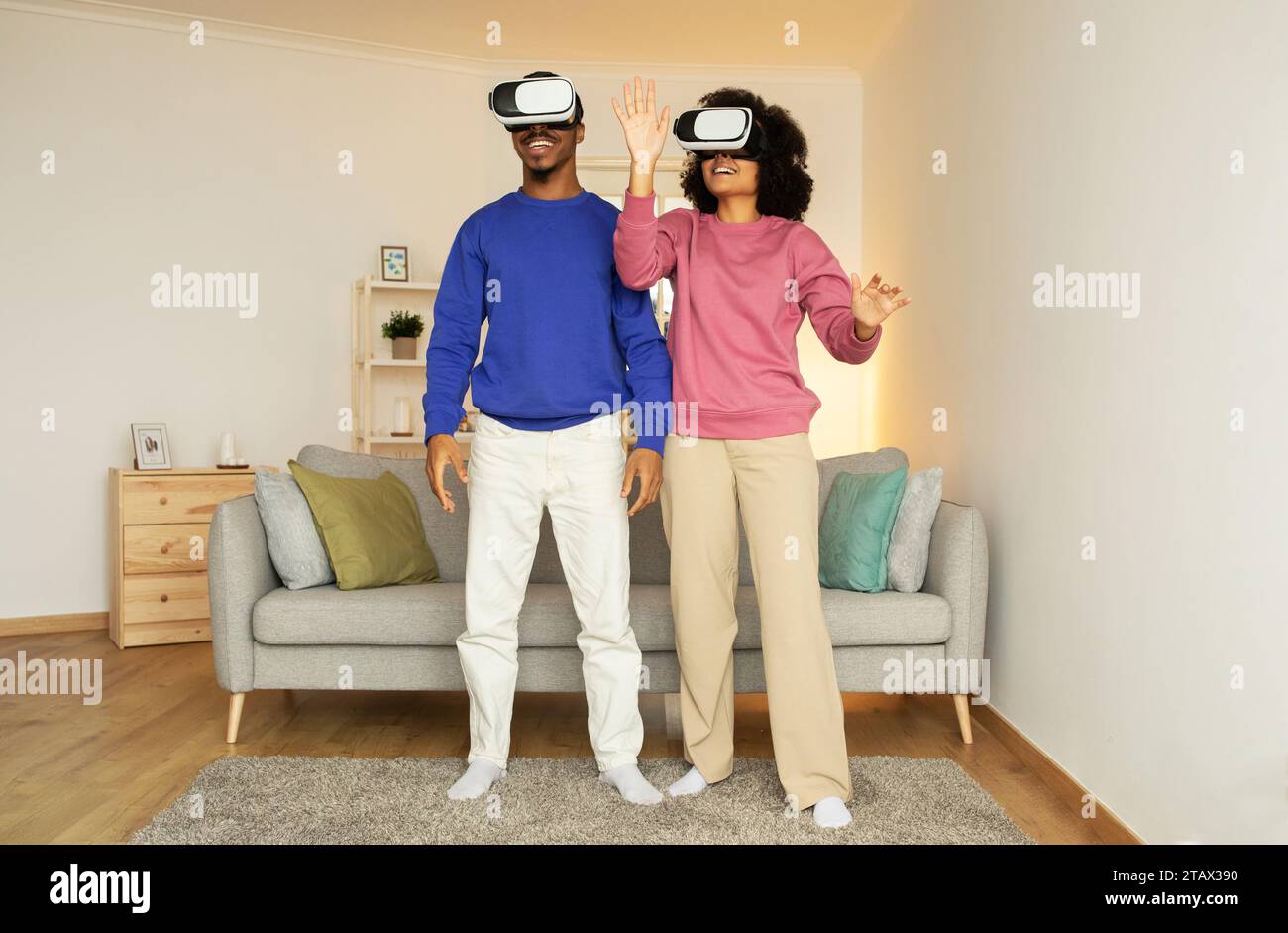Schwarzes Paar, das zu Hause in Virtual-Reality-Spiel eingetaucht ist Stockfoto