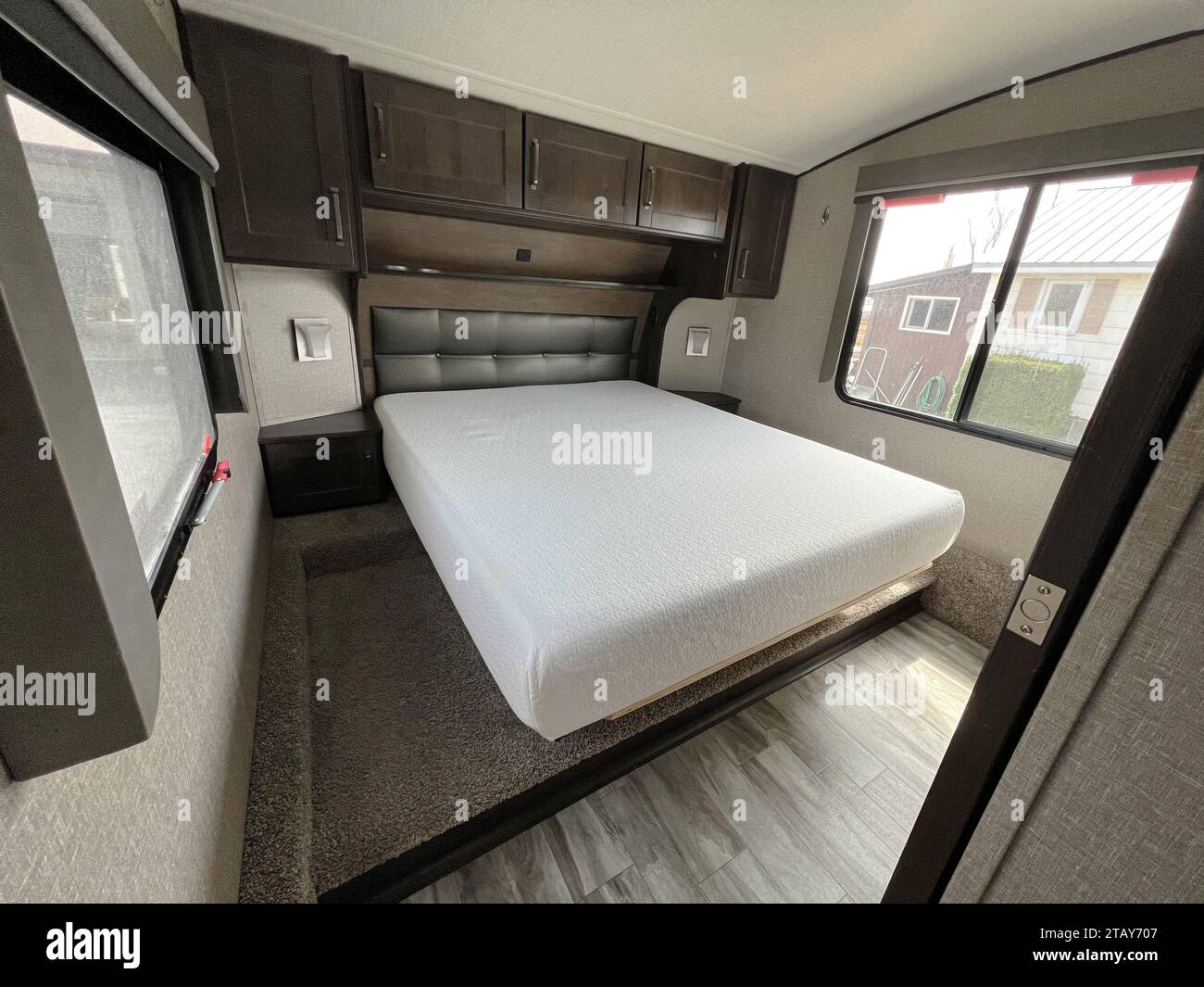 Helles und geräumiges Schlafzimmer eines neuen Luxus-Sattelanhängers oder Wohnwagens. Stockfoto