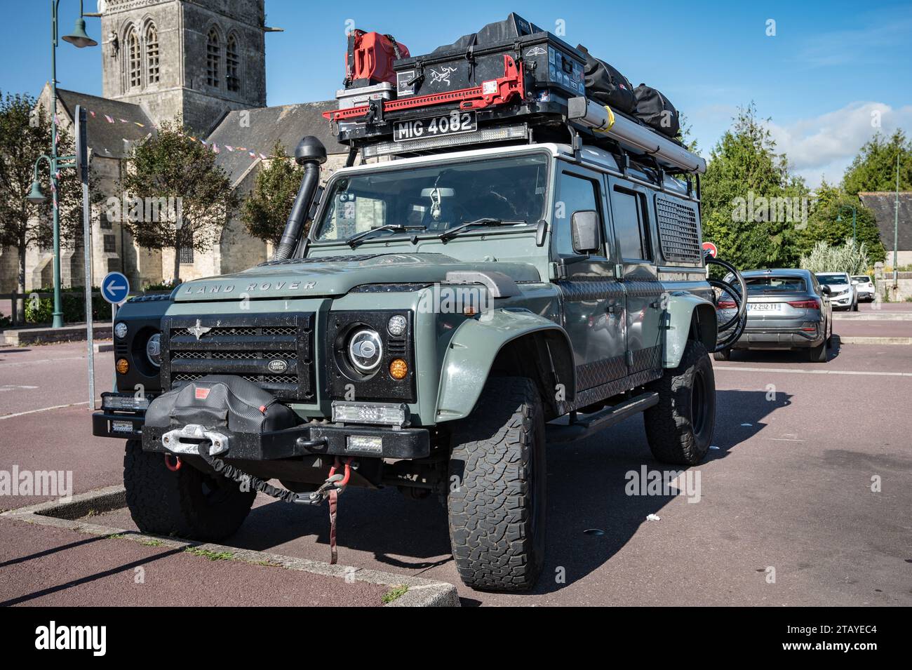 Vorderansicht eines schönen grünen englischen Land Rover Defender SUV, ausgestattet für Abenteuer mit dem Dachträger voller Werkzeuge und Zubehör Stockfoto