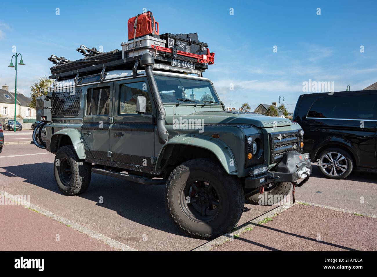 Vorderansicht eines schönen grünen englischen Land Rover Defender SUV, ausgestattet für Abenteuer mit dem Dachträger voller Werkzeuge und Zubehör Stockfoto