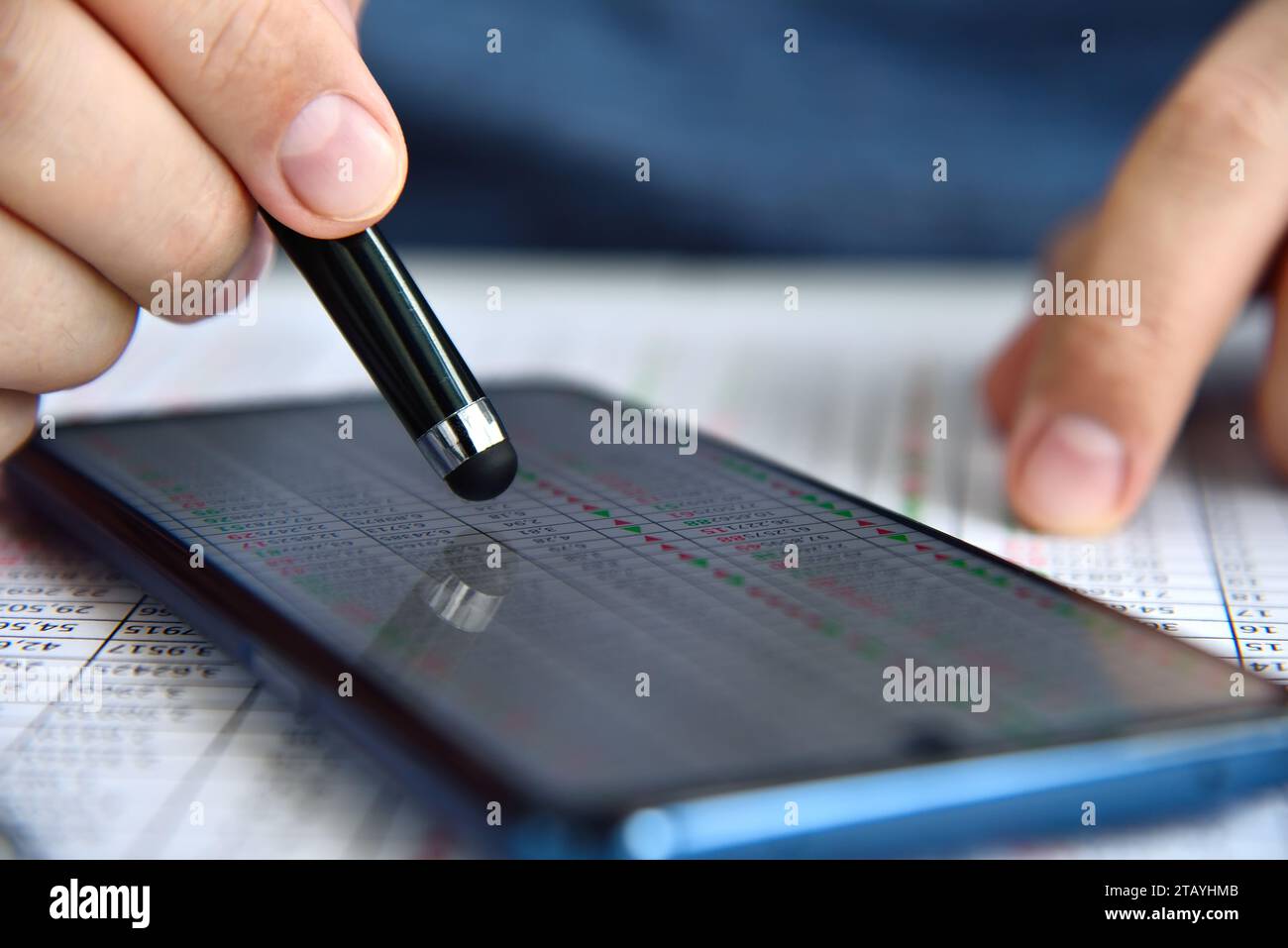 Händlermann mit Smartphone und Aktienstatistik auf dem Bildschirm. Internet-Handel und Geschäftskonzept. Nahaufnahme Stockfoto