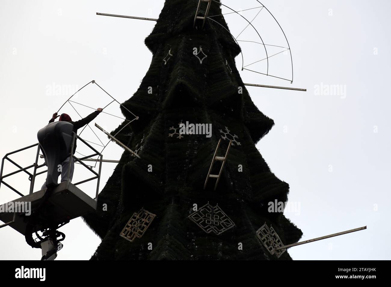 Ein Arbeiter wird gesehen, wie er einen Weihnachtsbaum auf Deribasowskaja installiert. Trotz des anhaltenden Krieges mit der Russischen Föderation wird der Neujahrsbaum auf der Hauptstraße von Odessa - Deribasowskaja installiert Nikolaustag, den die Ukraine zum ersten Mal nach dem julianischen Kalender am 6. Dezember feiern wird. Nach Angaben der Stadtverwaltung wird die Installation in diesem Jahr nicht aus dem Stadtbudget, sondern von Geschäftsleuten bezahlt, die anonym bleiben möchten (Foto: Viacheslav Onyschtschenko/SOPA Images/SIPA USA) Stockfoto