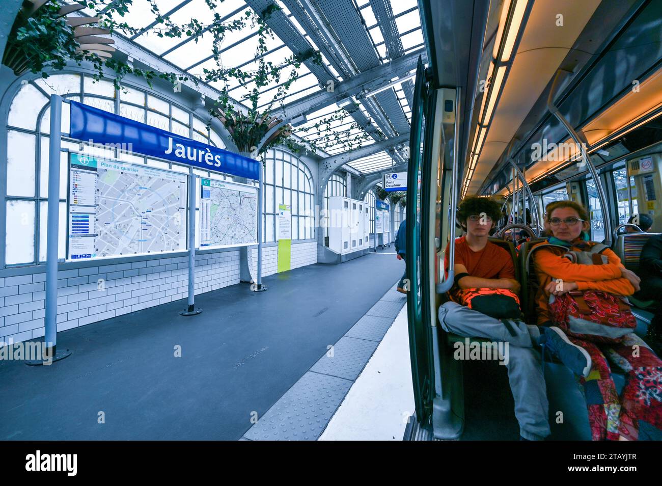 Paris, Frankreich. Juli 2022. An der U-Bahn-Haltestelle Jaures zwei Passagiere in der U-Bahn, ein junger Mann und eine Frau mittleren Alters. Sie halten ihre Rucksäcke Stockfoto