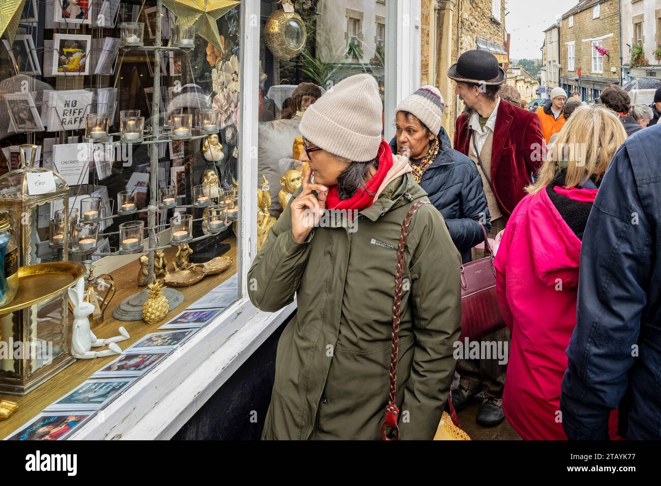 Käufer, die am 3. Dezember 2023 auf dem Frome Christmas Sunday Market in Frome, Somerset, Großbritannien, vor dem Fenster auf Catherine Hill schauen Stockfoto