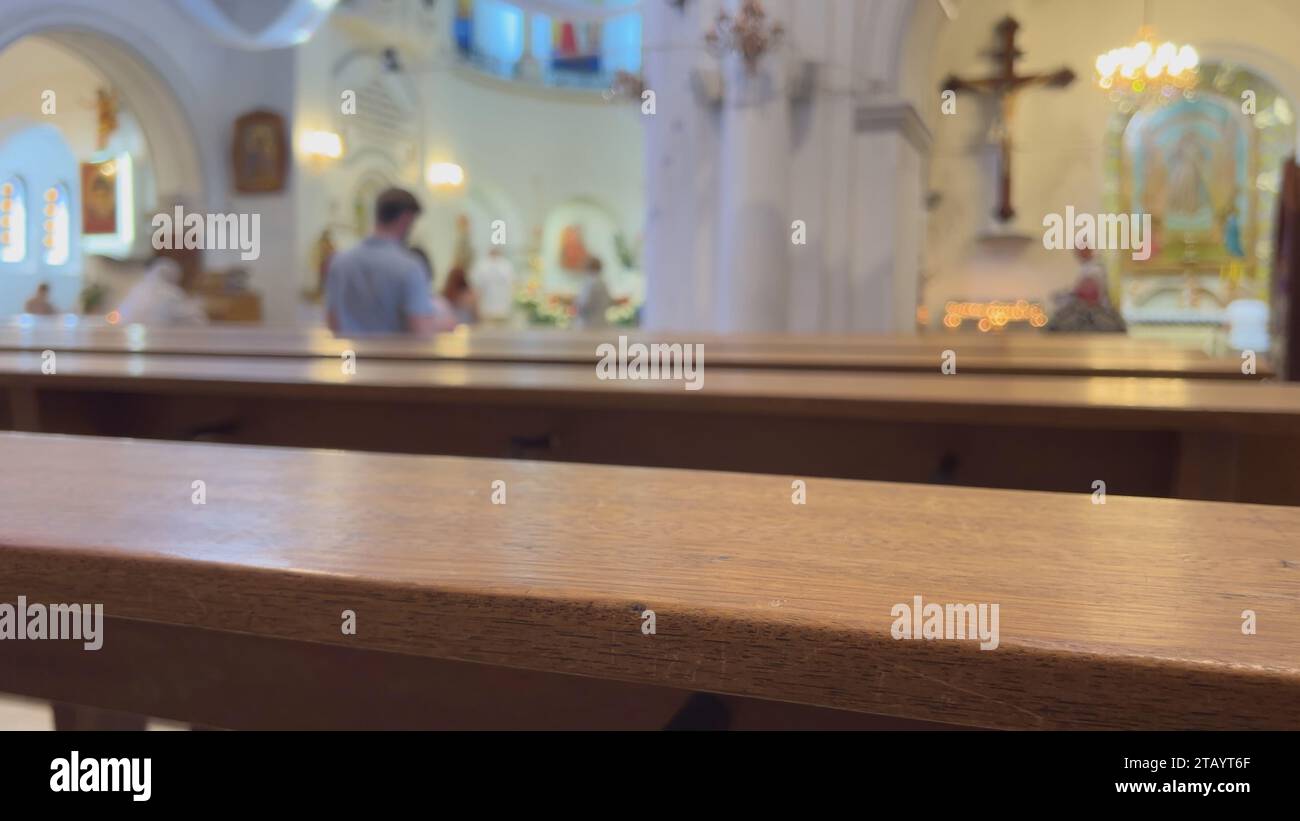 Gläubige in einer katholischen Kirche hinter den Bänken. Stockfoto