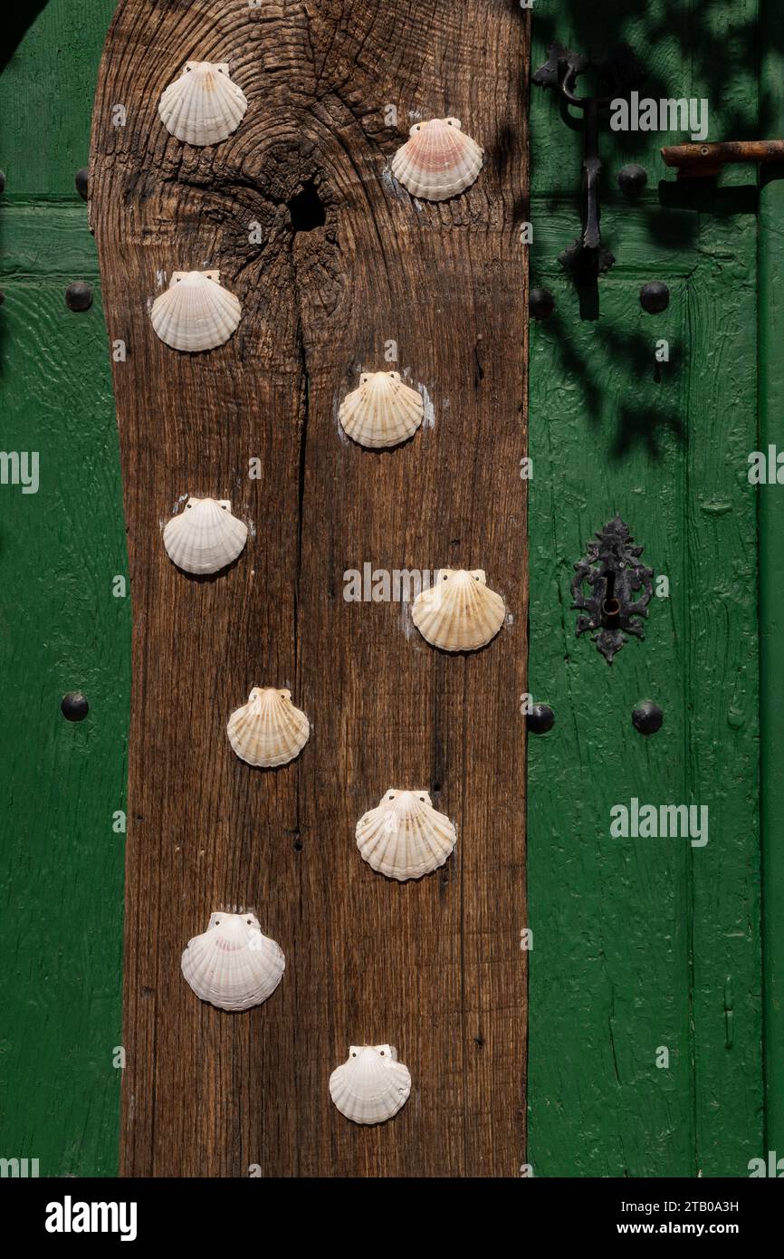Jakobsmuscheln zieren eine traditionelle Tür im Dorf Castrillo de los Polvazares in Maragato entlang des französischen Jakobsweges in Leon, Spanien. Die Jakobsmuschel Stockfoto