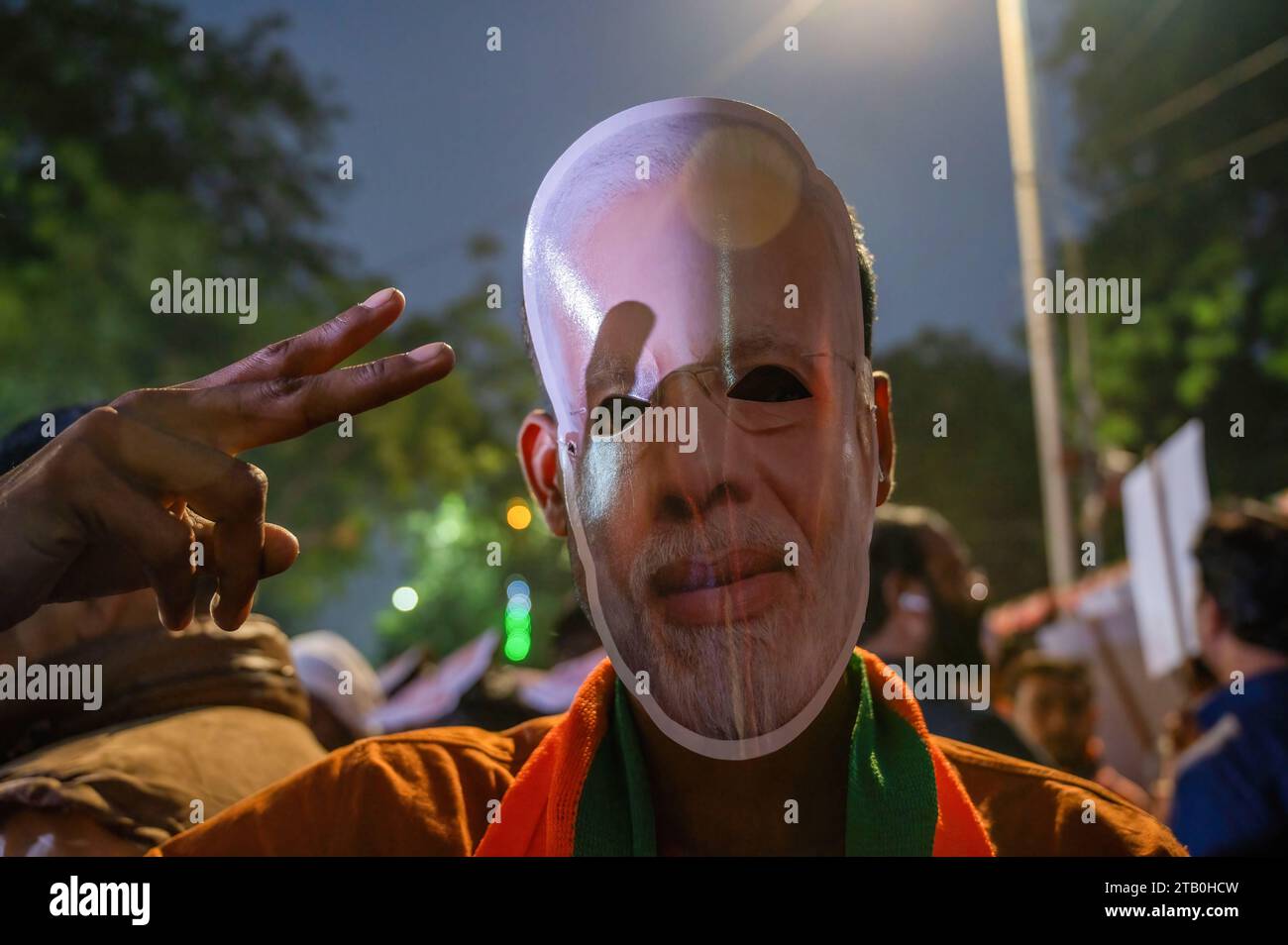 Neu-Delhi, Indien. Dezember 2023. Ein BJP-Unterstützer trägt eine Narendra-Modi-Maske, während er den Sieg bei den Wahlen in Madhya Pradesh, Chhattisgarh und Rajasthan im Hauptquartier der BJP feiert. In Indien fanden vor kurzem vier Wahlen zur Staatsversammlung statt, und die Bharatiya Janata Party (BJP) wird die Regierung in Madhya Pradesh, Chhattisgarh und Rajasthan bilden. (Foto: Pradeep Gaur/SOPA Images/SIPA USA) Credit: SIPA USA/Alamy Live News Stockfoto