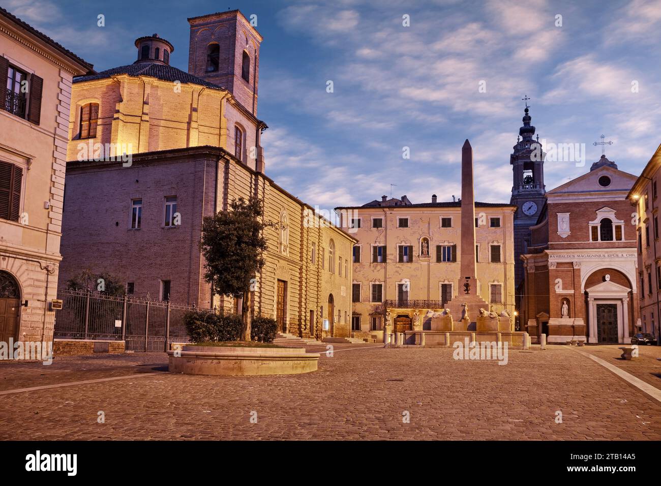 Jesi, Ancona, Marken, Italien: Der mittelalterliche Platz Federico II mit dem Obelisken, der Kathedrale, den antiken Gebäuden und der bauminsel mit arabischem insc Stockfoto