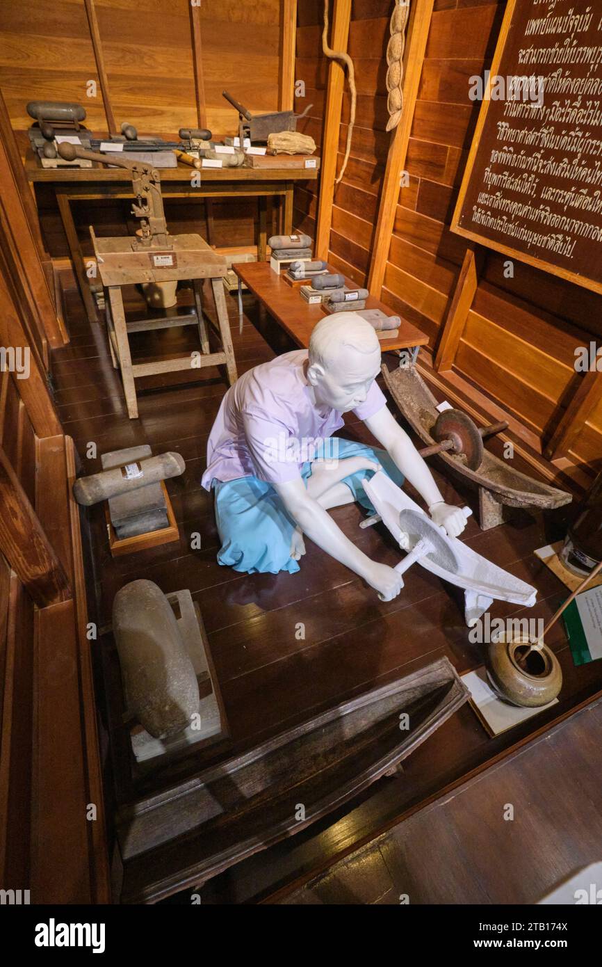 Ein Apotheker mahlt traditionelles Medecin, Drogen. In einer Nachbildung einer alten Apotheke im asiatischen Stil. Teil des Siriraj Piyamaharajkarun Hospital Exhibi Stockfoto