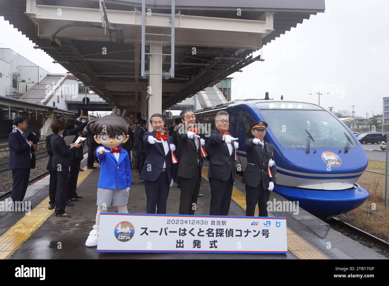 Tottori, Japan. Dezember 2023. Mitarbeiter posieren für Fotos während der Einführungszeremonie für den Detective Conan-Zug am Bahnhof Kurayoshi in Tottori, Japan, 3. Dezember 2023. Ein spezieller Expresszug mit Charakteren des berühmten Manga „Detective Conan“ fuhr am Sonntag an der Kurayoshi Station in Japans Manga-Hub in der Präfektur Tottori ab, als die Region Touristen aus dem in- und Ausland anziehen wollte. Quelle: Cheng Jing/Xinhua/Alamy Live News Stockfoto