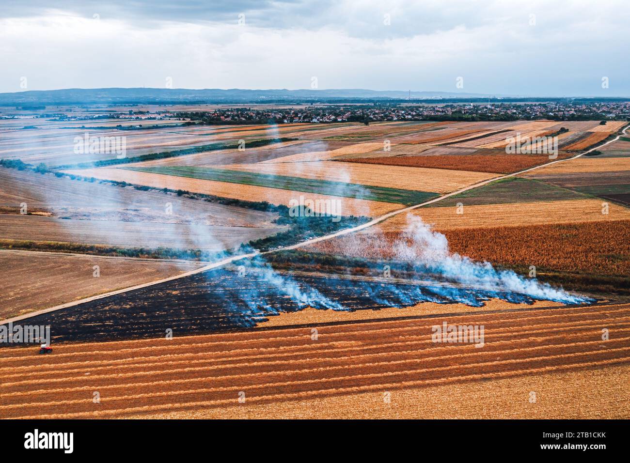 Die Verbrennung von Weizenfeldern nach der Ernte von Körnern ist eine der Hauptursachen für Luftverschmutzung, Luftaufnahme von Drohnen-pov, Hochwinkelansicht Stockfoto