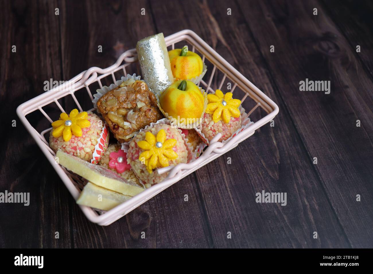 Indische Diwali-Süßigkeiten oder Mithai mit Diya und Blumen. Festliche Geschenkidee. Kaju Katli, Trockenfrüchte Peda, Barfi, Cashewnuss Barfi, Marzipans. Stockfoto