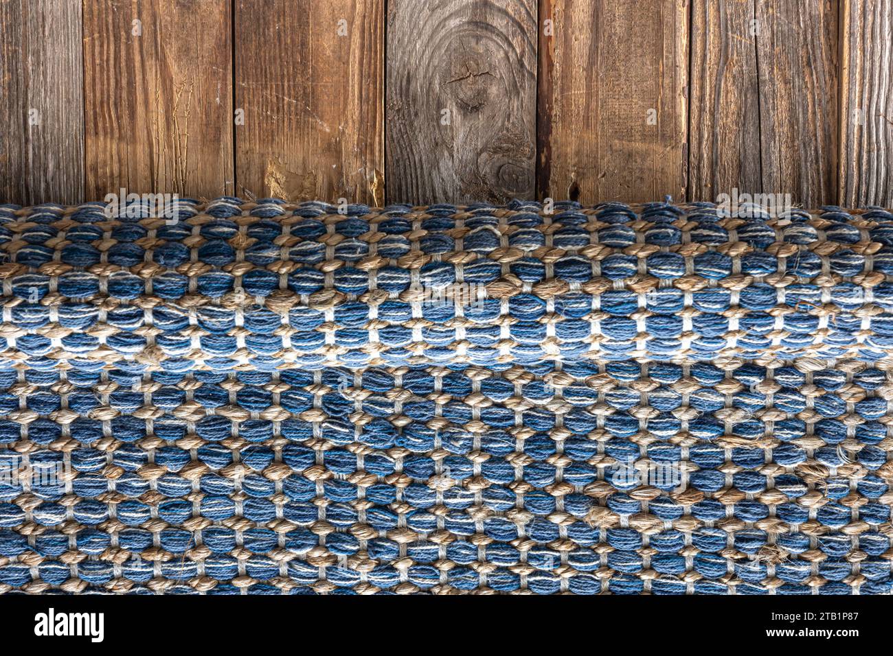 Handgewebter Teppich mit geometrischem Denim-Bereich auf Holzboden. Stockfoto