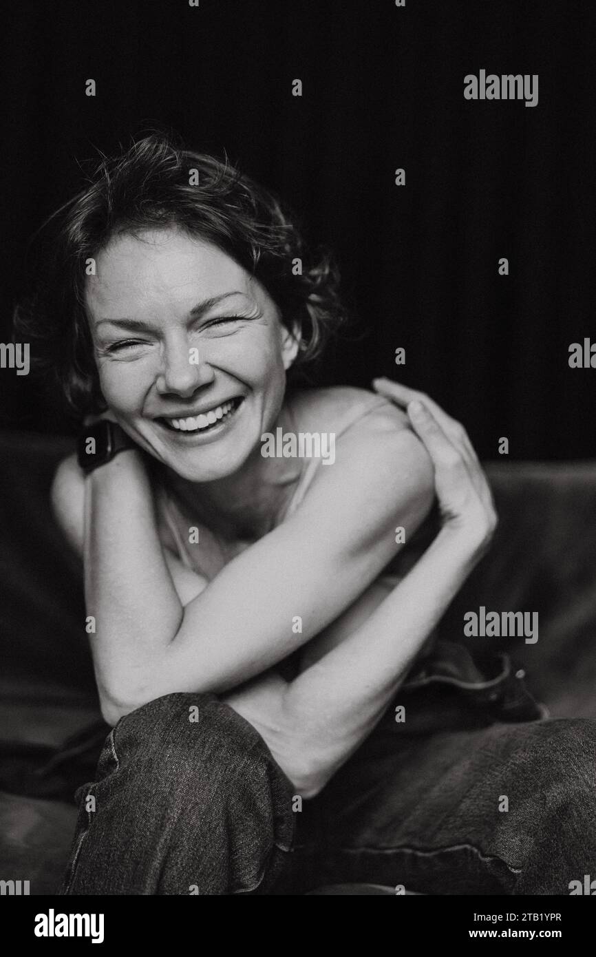 Lächelnde Frau mit kurzen Haaren, schwarz-weißem emotionalem Porträt. Stockfoto