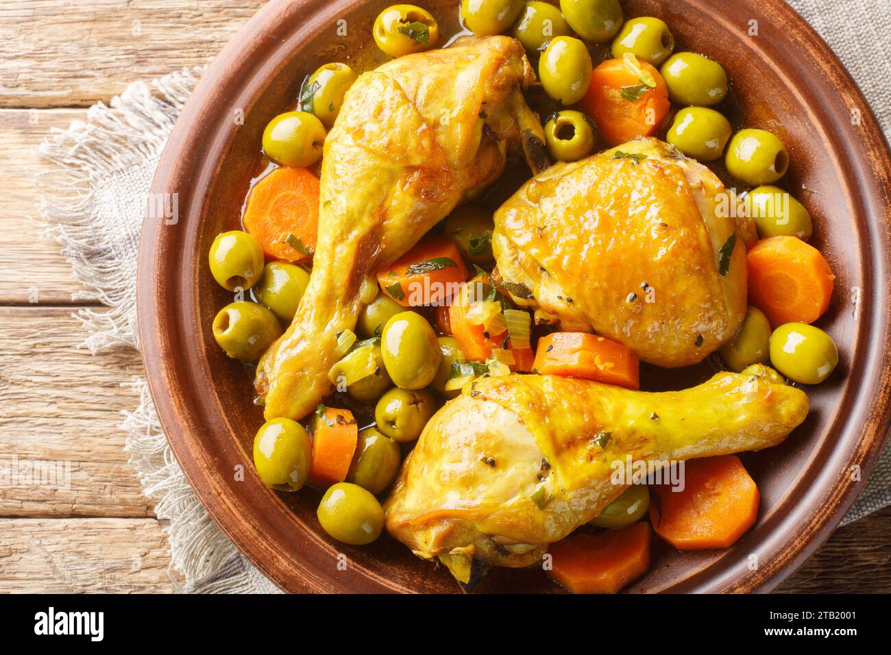 Tajine zitoune ist eine Hühnermischung Gemüse und Gewürze Küche aus nächster Nähe auf Holztisch. Horizontale Draufsicht von oben Stockfoto