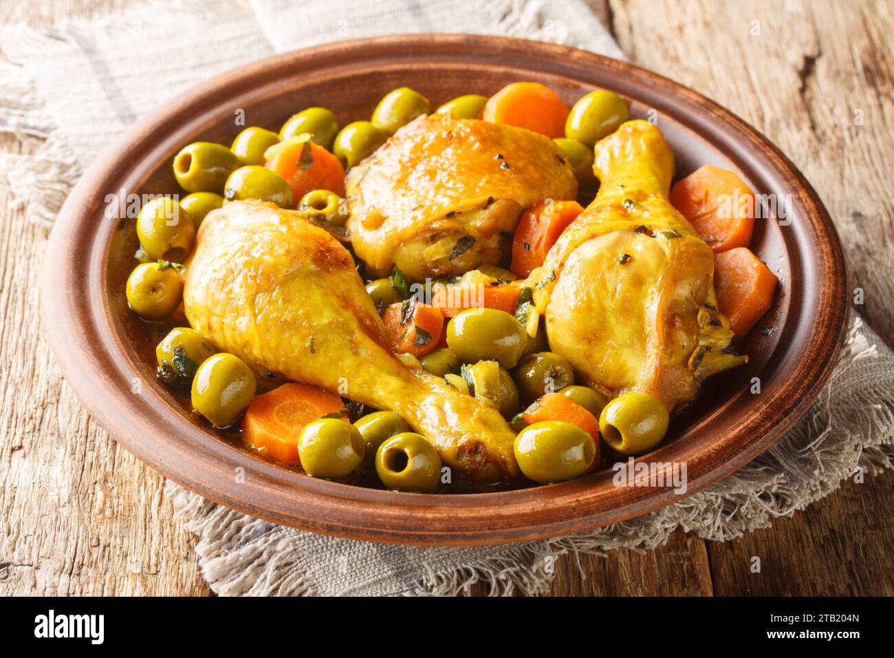 Tajine zitoune ist eine Hühnermischung Gemüse und Gewürze Küche aus nächster Nähe auf Holztisch. Horizontal Stockfoto