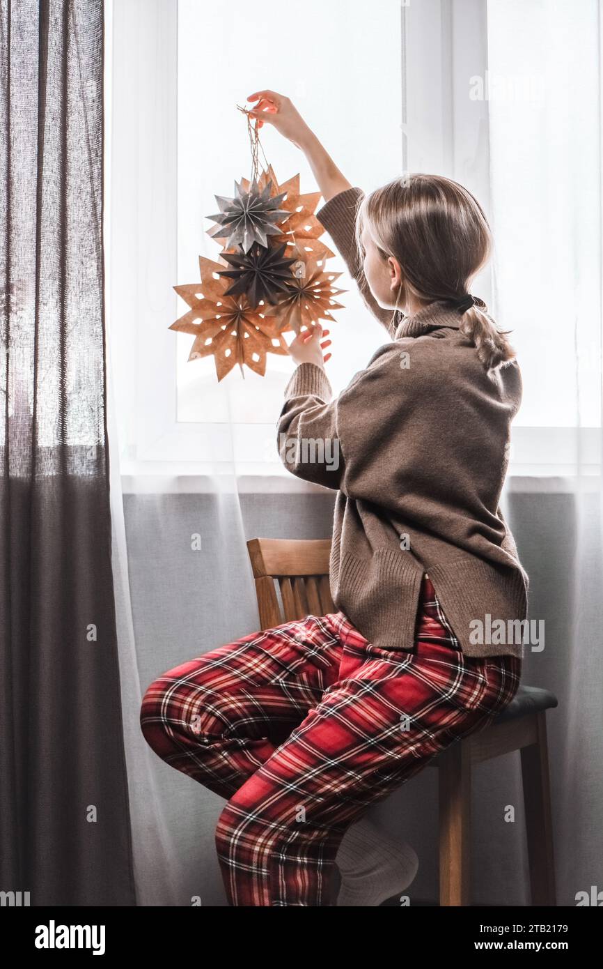 Frau, die Haus dekoriert weihnachtspapier Handwerk Sterne. Umweltfreundlich gemütlich Stockfoto