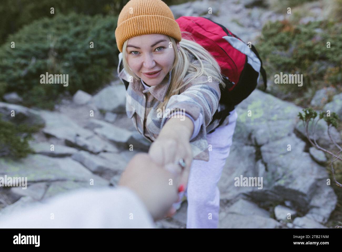 First-Person-Ansicht einer Reisenden, die einen Felsen klettert, Stockfoto